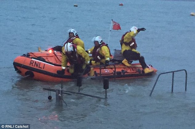 Firefighters and a lifeboat crew worked together to pull her out and brought her back to safety