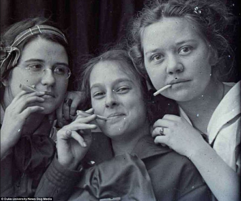 A group of young women smoke and pose for the camera in the US in about 1900 