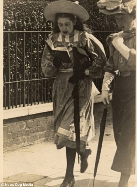 A young girl reading from a book in London